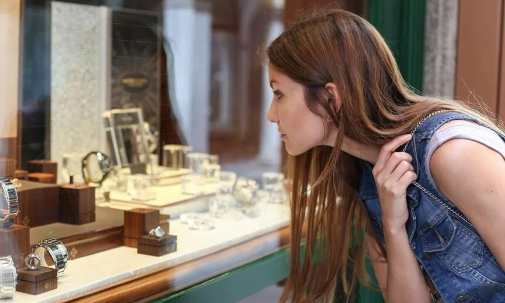 A woman looking at the jewelry on a store.