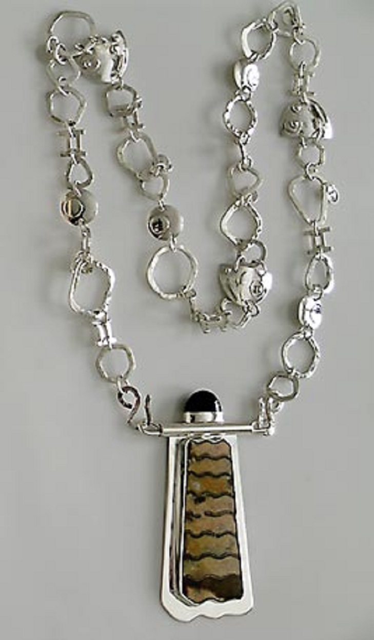 A baculite fossil pendant with silver chain