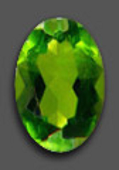 A polished oval-shaped green chrome diopside with several facets