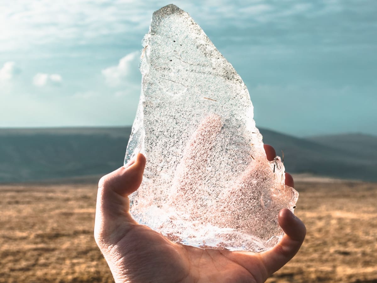 Person Holding White Transparent Crystal