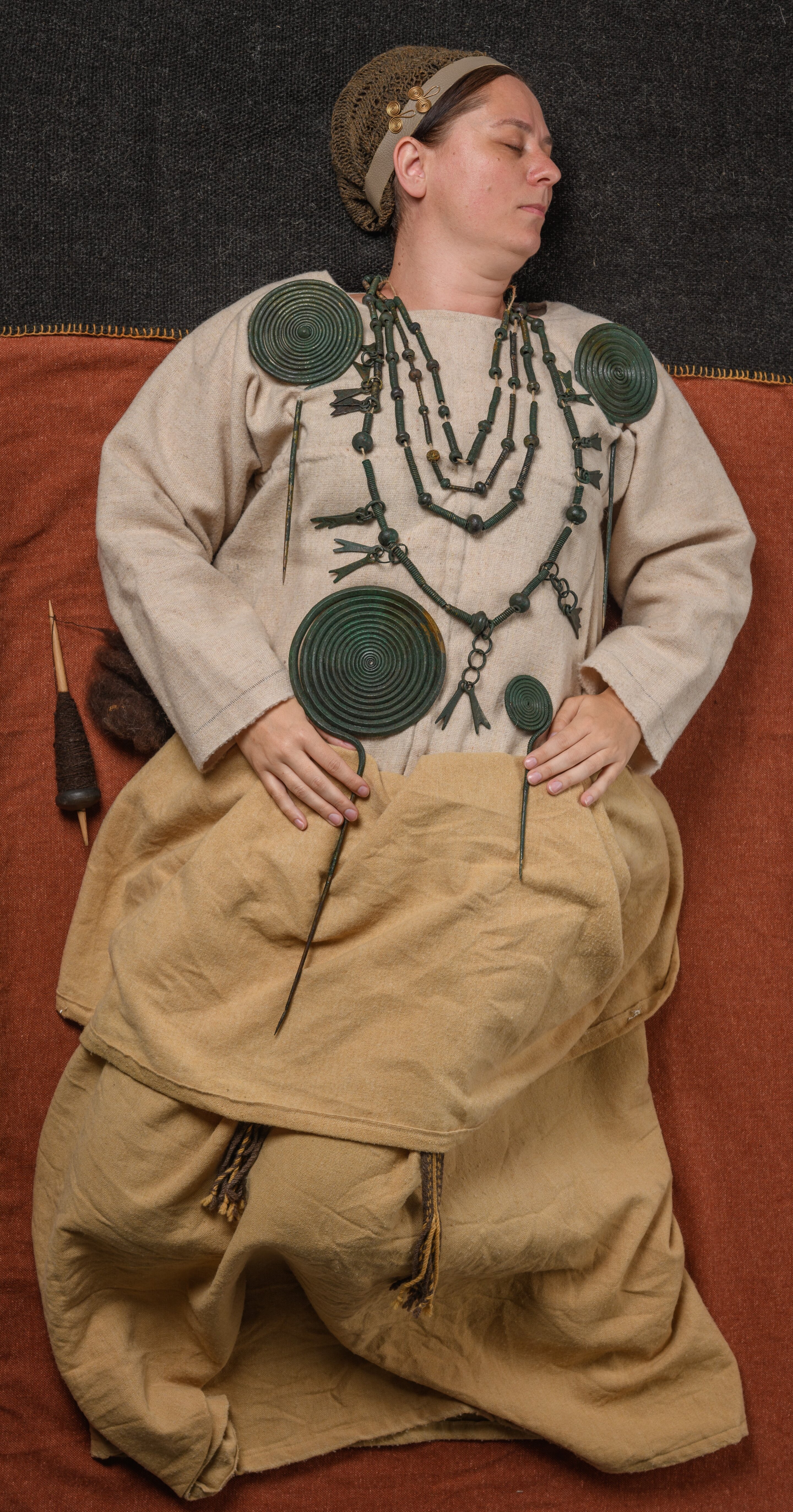 A wooman wearing a prehistoric bronze jewelry for burial rituals