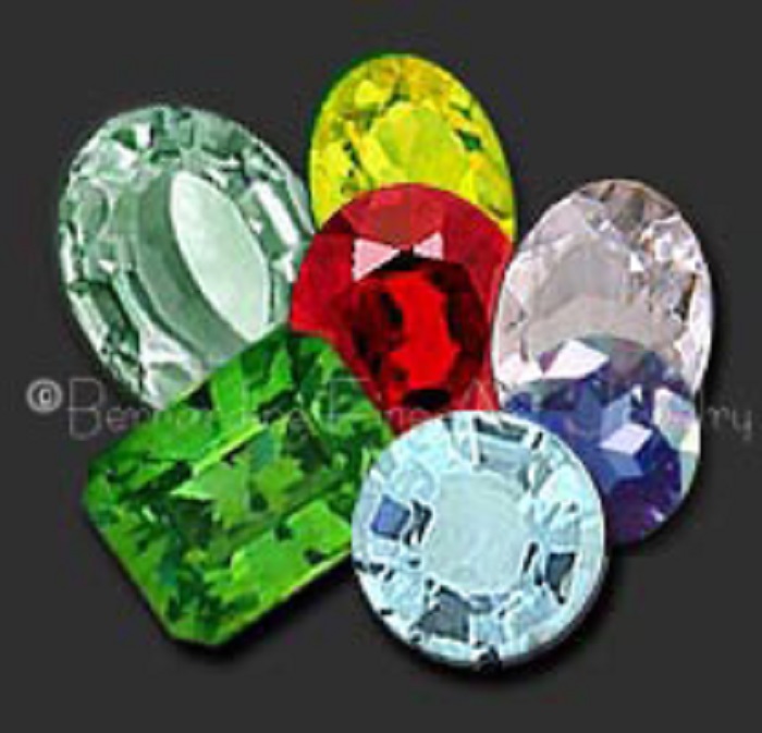 Seven polished beryl gemstones mostly in circle and oval shape, with one rectangular green beryl
