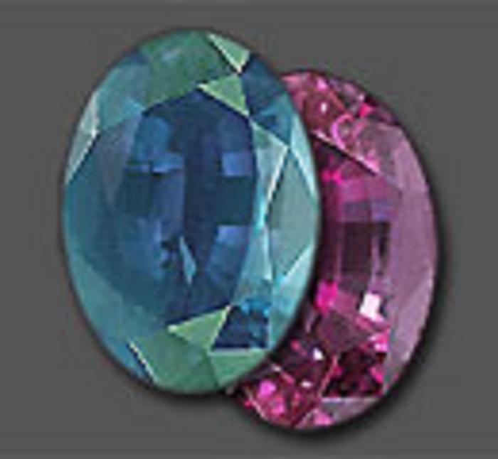 Two multi-faceted oval-shaped alexandrite gemstones in blue and purple