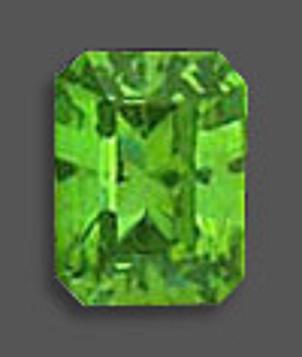 A rectangular demantoid green garnet with polished surface and in a bright shade of green