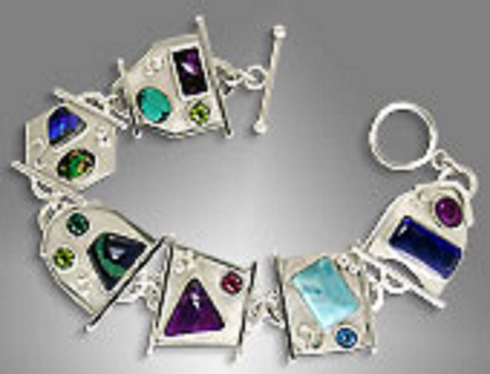 A sterling silver link bracelet with six links in different shapes and each with two to three gemstones