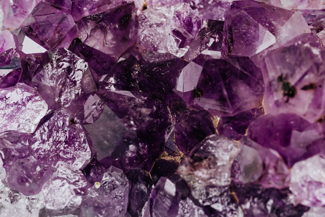 Natural Crystal Minerals Placed on Tableset of Shiny Transparent Amethysts Grown Together