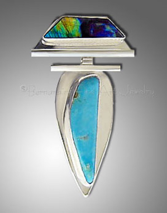 A turquoise pendant shaped like an upside-down leaf in silver, with a trapezoid-shaped spectrolite on top