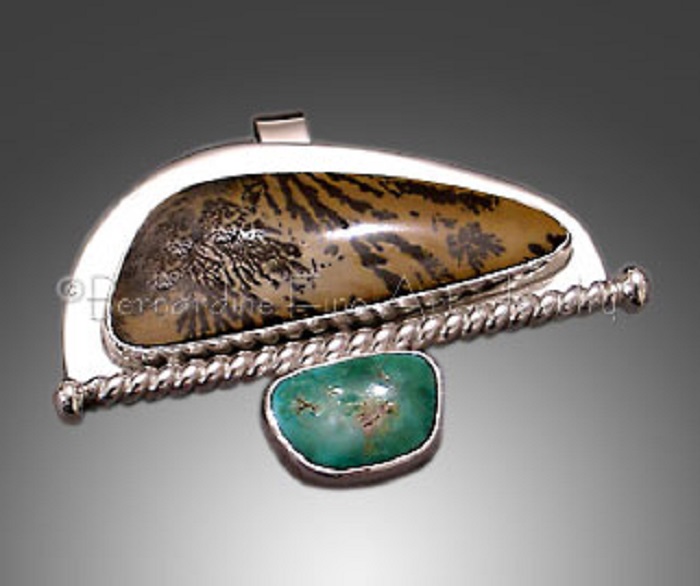 A silver pendant with turquoise and scalene-triangle-shaped brown moss agate with black patterns and curved edges